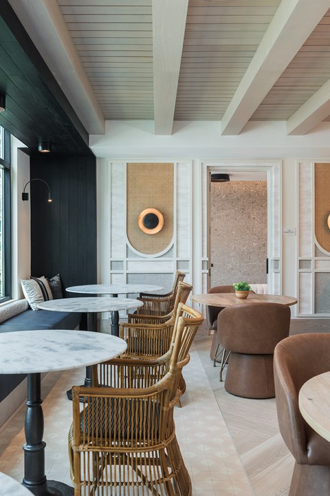 A room with a white table and brown chairs.