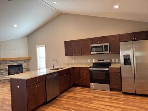 A modern kitchen with wooden cabinets and stainless steel appliances.