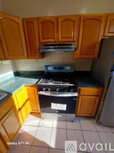 A kitchen with wooden cabinets and a black stove top oven.