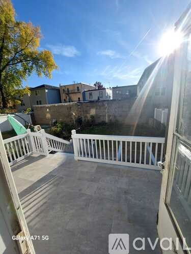 A balcony with a white railing and a view of buildings.