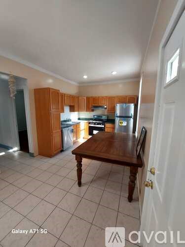 A kitchen with wooden cabinets and a white fridge is shown.
