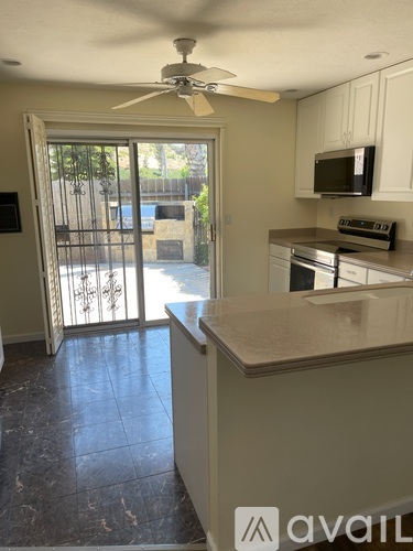 A kitchen with a fan on the ceiling and a countertop.