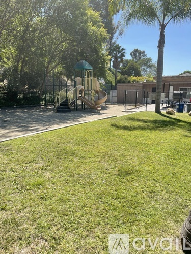 A playground with a slide and a green roofed structure.