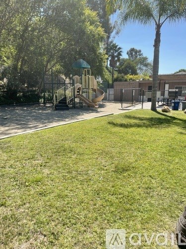 A playground with a slide and a green roofed structure.