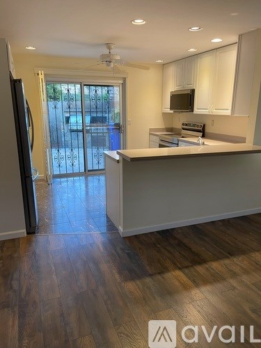 A kitchen with a refrigerator on the left and a microwave above the stove.