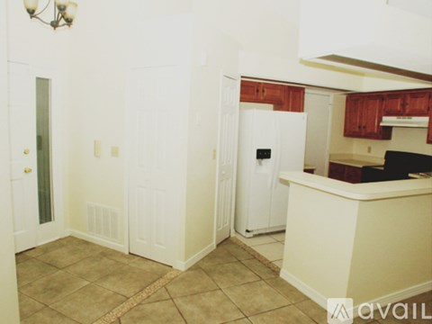 A kitchen with white appliances and wooden cabinets.