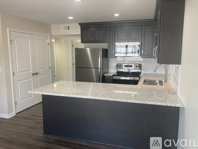 A kitchen with a granite countertop and stainless steel appliances.