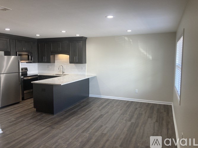 A kitchen with a black countertop and stainless steel appliances.
