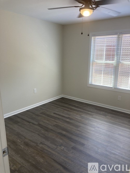 A room with a ceiling fan and a window with blinds.