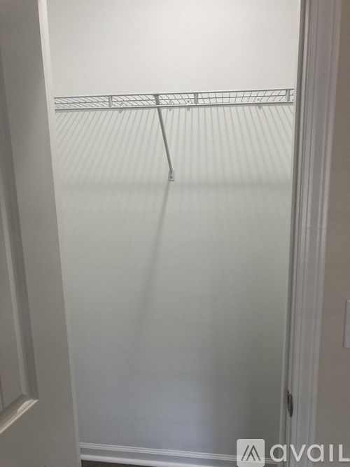 A white door with a metal handle and a small metal rack above it.