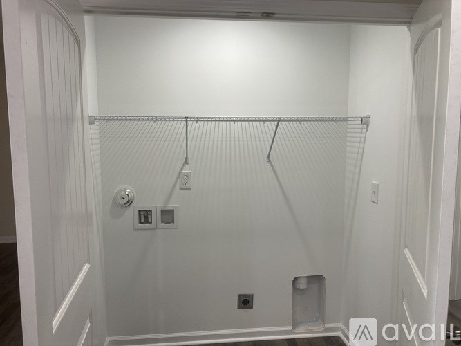 A white closet with a metal rod and hooks.
