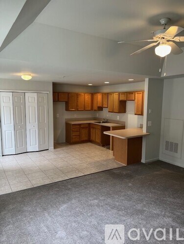 A spacious kitchen with white cabinets and a wooden island.