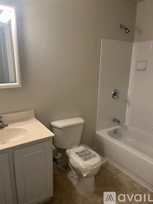 A bathroom with a toilet, sink, and bathtub.