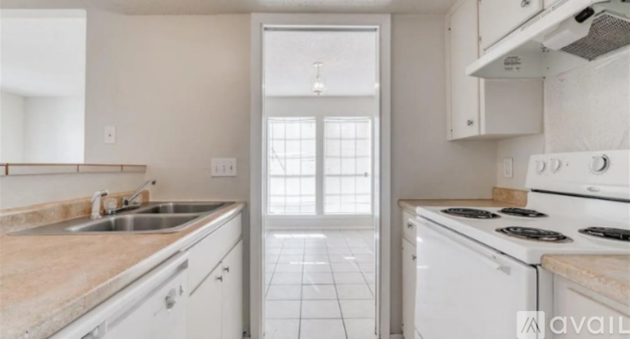A kitchen with white appliances and a marble countertop.