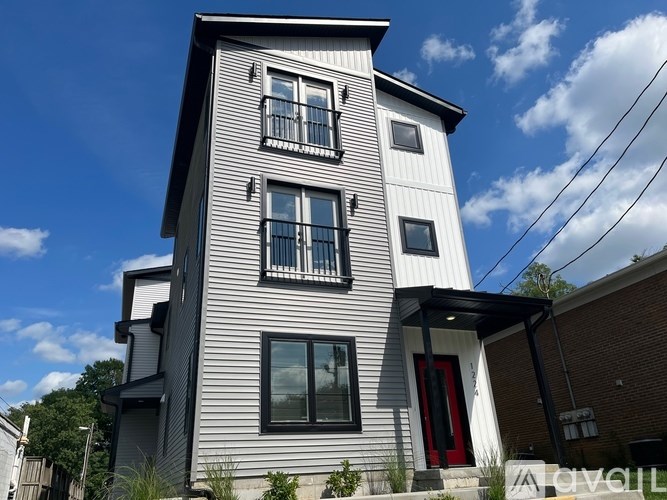 A two-story house with a red door and a balcony.