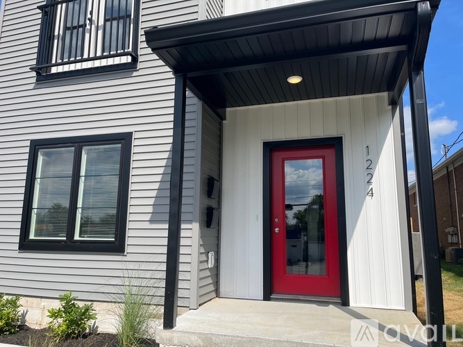 A house with a red door and a black awning.