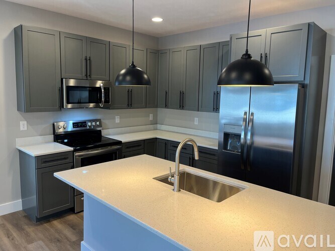 A kitchen with a stainless steel refrigerator and a white countertop.
