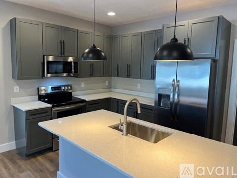 A kitchen with a stainless steel refrigerator and a white countertop.
