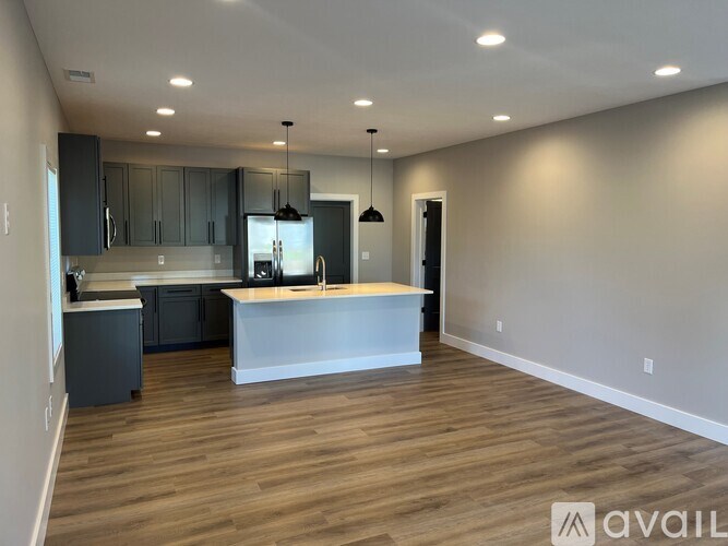 A spacious kitchen with a center island and pendant lights.