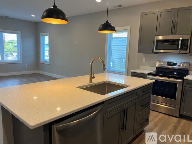 A kitchen with a sink, stove, and oven.