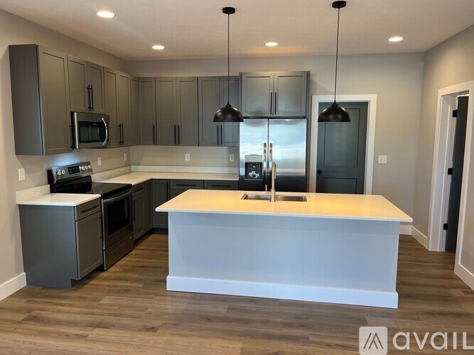 A modern kitchen with a center island and stainless steel appliances.