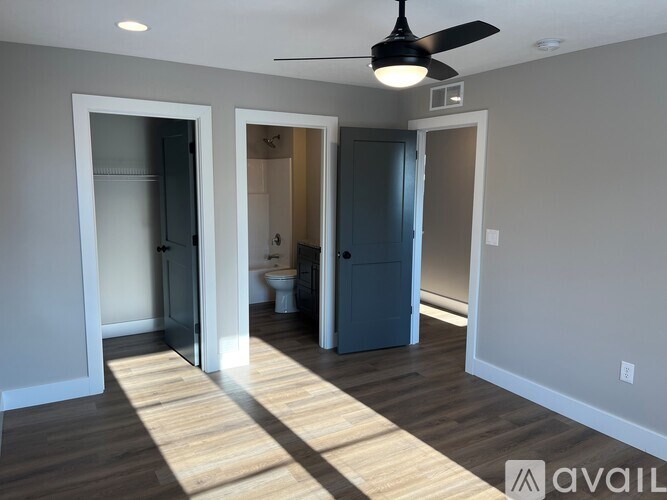 A room with a ceiling fan and a wooden floor.