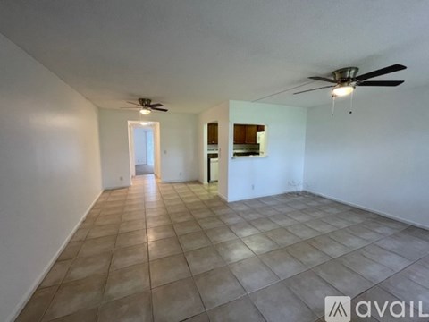 A spacious room with a ceiling fan and tiled flooring.