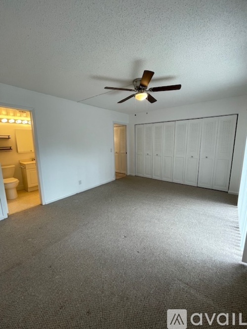 A room with a ceiling fan and a carpeted floor.