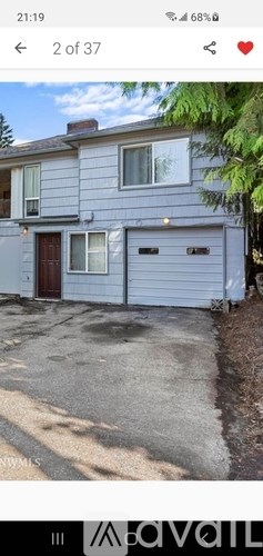 A two-story house with a garage door and a window on the second floor.