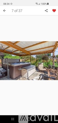 A patio with a hot tub and a table.
