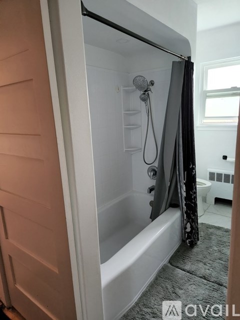 A bathroom with a white tub and a shower curtain.