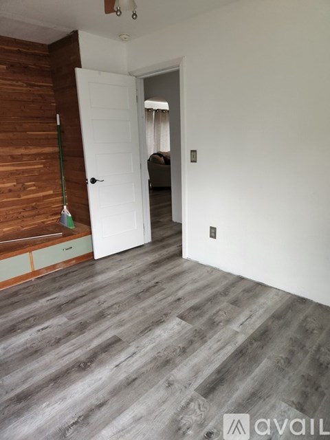 A room with a white door and a wooden wall.