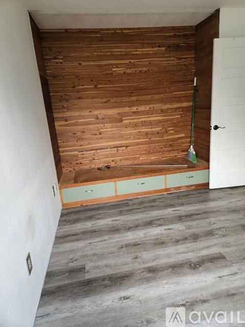 A room with a wooden wall and grey floor.