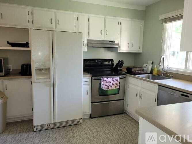 A kitchen with white appliances and cabinets.