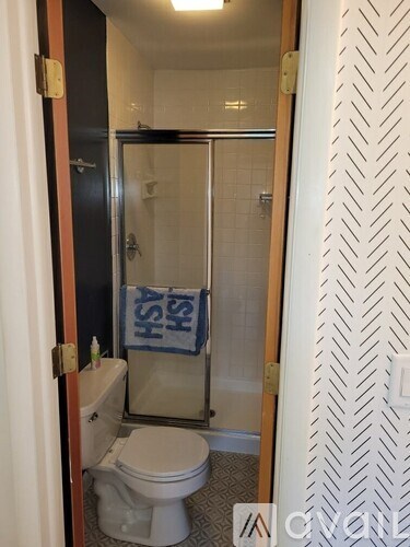 A bathroom with a toilet, sink and shower.