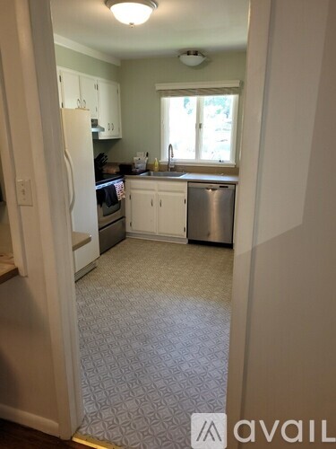 A kitchen with white cabinets and a patterned floor.