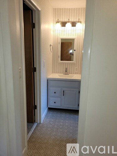 A bathroom with a mirror and a cabinet.