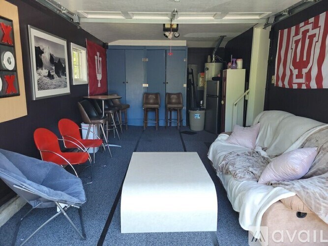 A room with a bed, chairs, and a table.