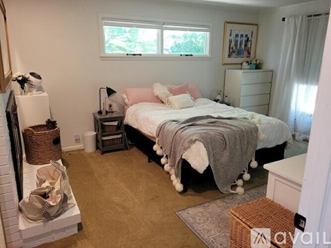 A bedroom with a large bed and a fireplace.