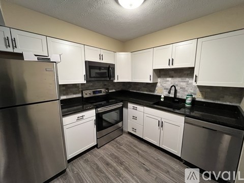 A kitchen with white cabinets and stainless steel appliances.
