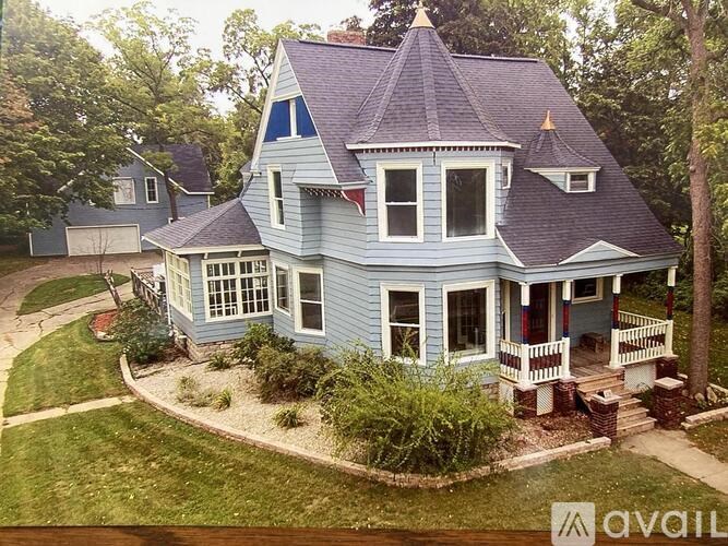 A blue house with a porch and a small front yard.