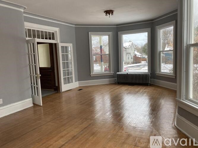 A room with wooden floors and a large window.