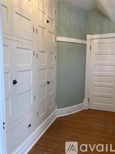 A room with white doors and wooden floors.