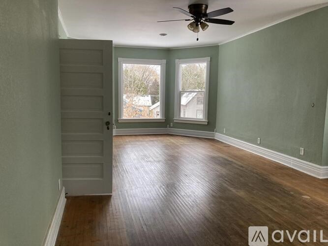 A room with a wooden floor and a ceiling fan.