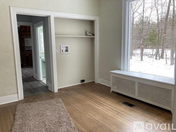 A room with a window and a door leading to another room.