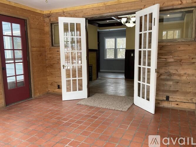 A room with a red door and a white door with windows.