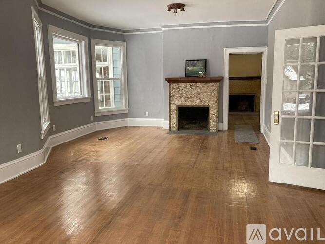 A living room with a fireplace and a painting on the wall.