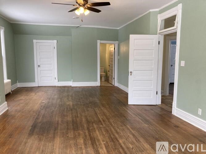 A room with wood flooring and a ceiling fan.
