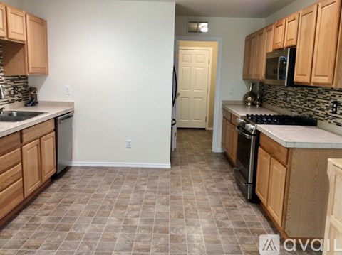 A kitchen with wooden cabinets and a tiled floor.