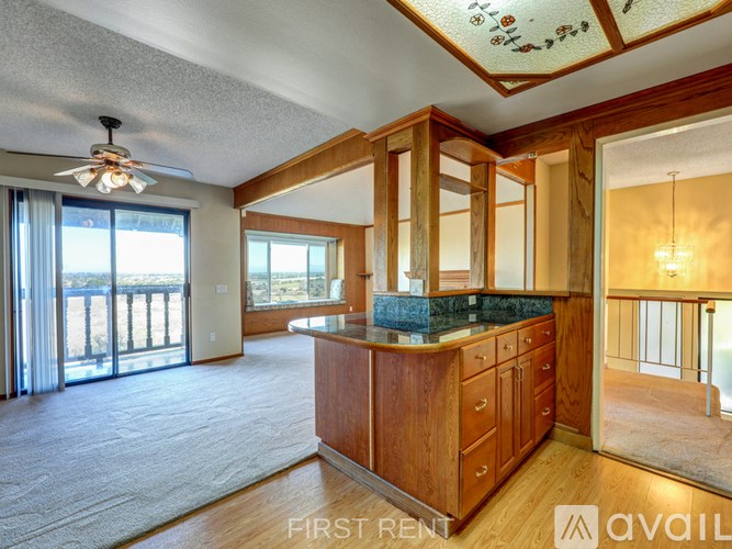 A room with a carpeted floor and a door leading to another room.